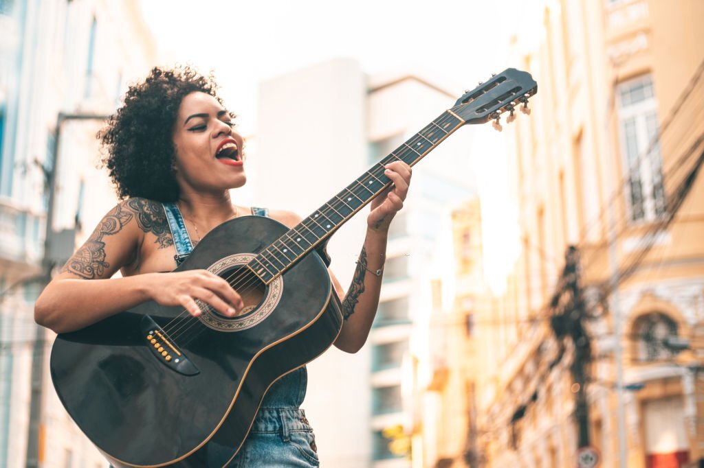 Pemusik Wanita Bertato Sedang Bernyanyi